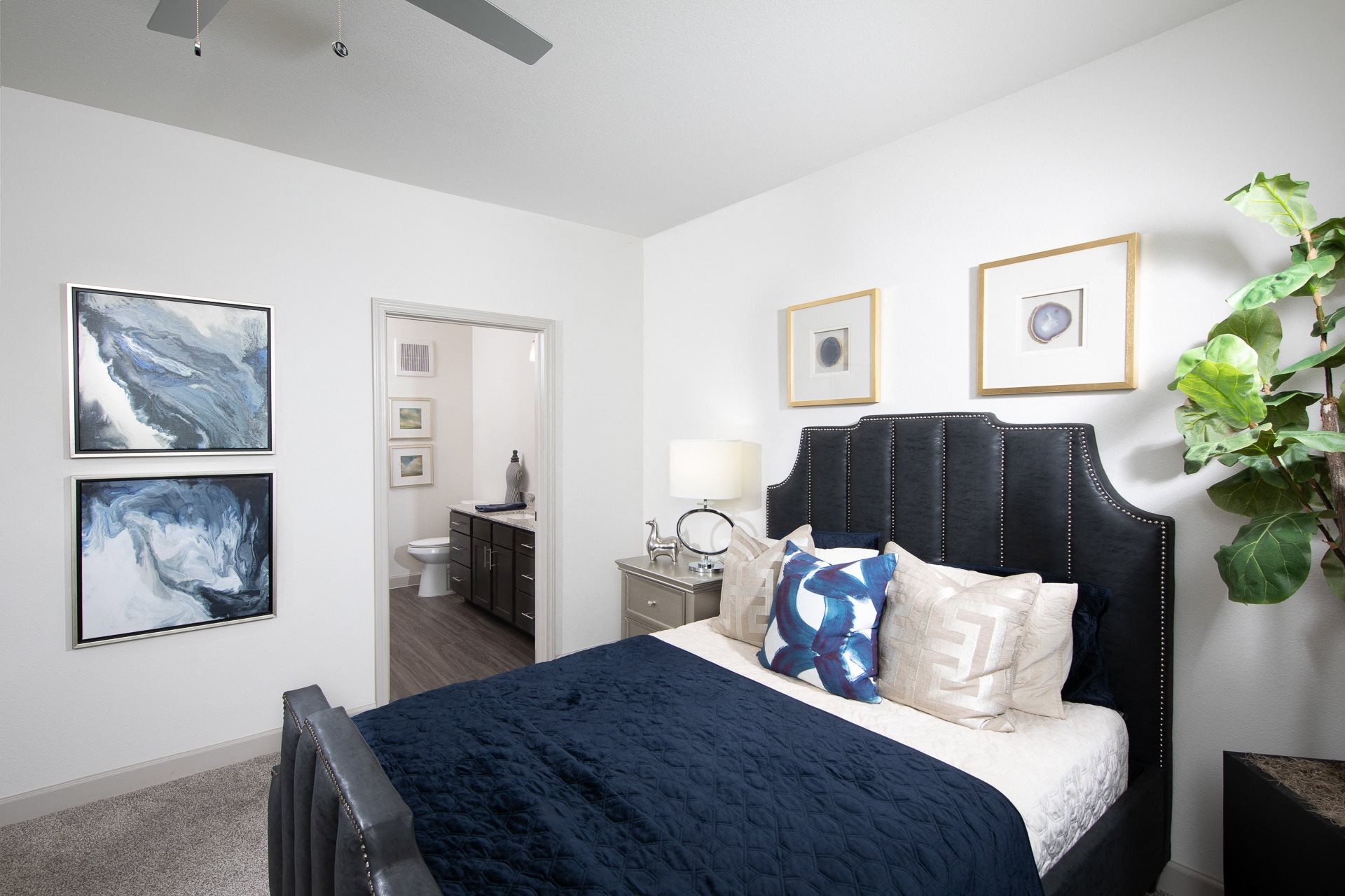a bedroom with a queen-sized bed and ceiling fan at a senior apartment community